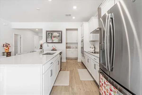 a kitchen with kitchen island white cabinets and appliances