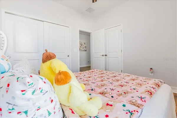 a bedroom with a bed a fireplace and two large window
