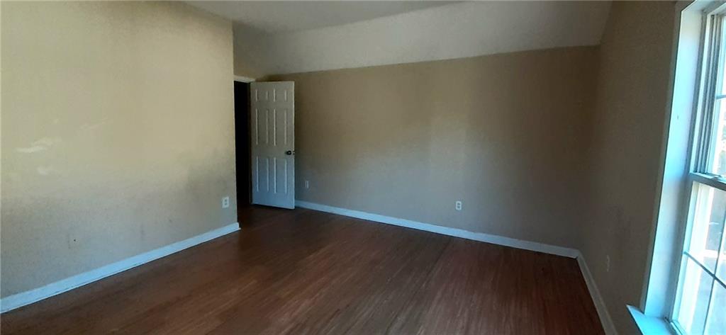 51 Pine Avenue Commerce, GA 30529 - Photo 19 of 24 a view of an empty room with wooden floor and a window