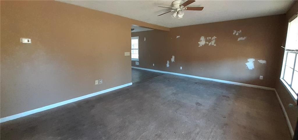51 Pine Avenue Commerce, GA 30529 - Photo 6 of 24 an empty room with a ceiling fan and window