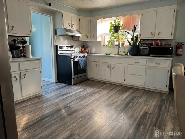a kitchen with a white cabinets sink and stainless steel appliances