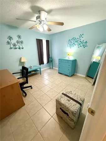 a bedroom with a bed a chandelier and dresser
