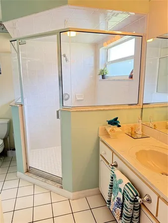 a bathroom with a granite countertop sink a mirror and shower