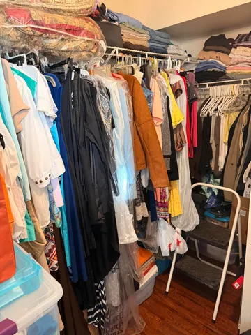 a view of walk in closet with clothes and shoes