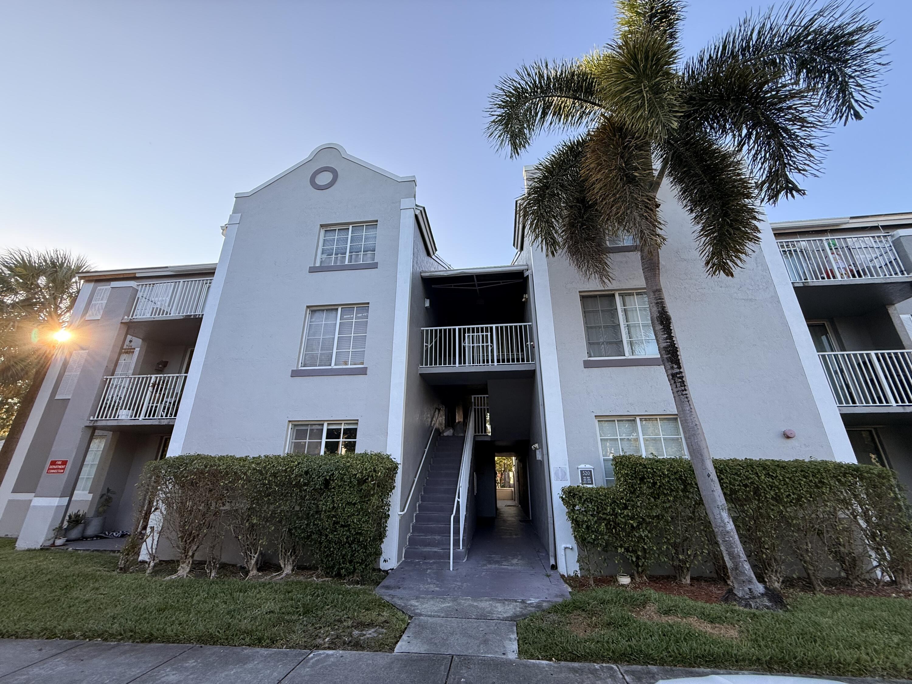 520 Southwest 111th Avenue, Unit 202 Pembroke Pines, FL 33025 - Photo 20 of 20 a front view of a house with a yard and palm tree