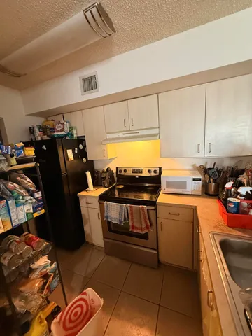 a kitchen with stainless steel appliances a stove a sink and a refrigerator