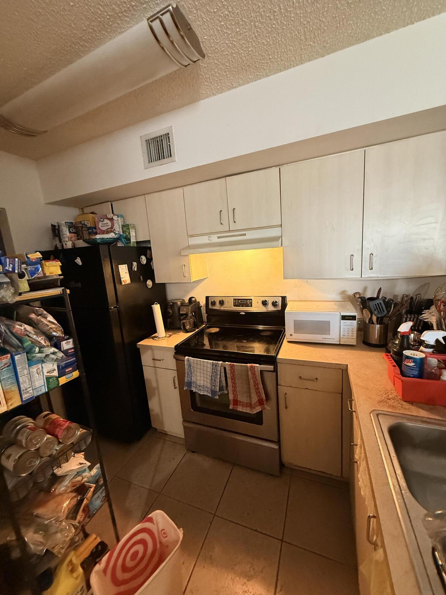 520 Southwest 111th Avenue, Unit 202 Pembroke Pines, FL 33025 - Photo 5 of 20 a kitchen with stainless steel appliances a stove a sink and a refrigerator