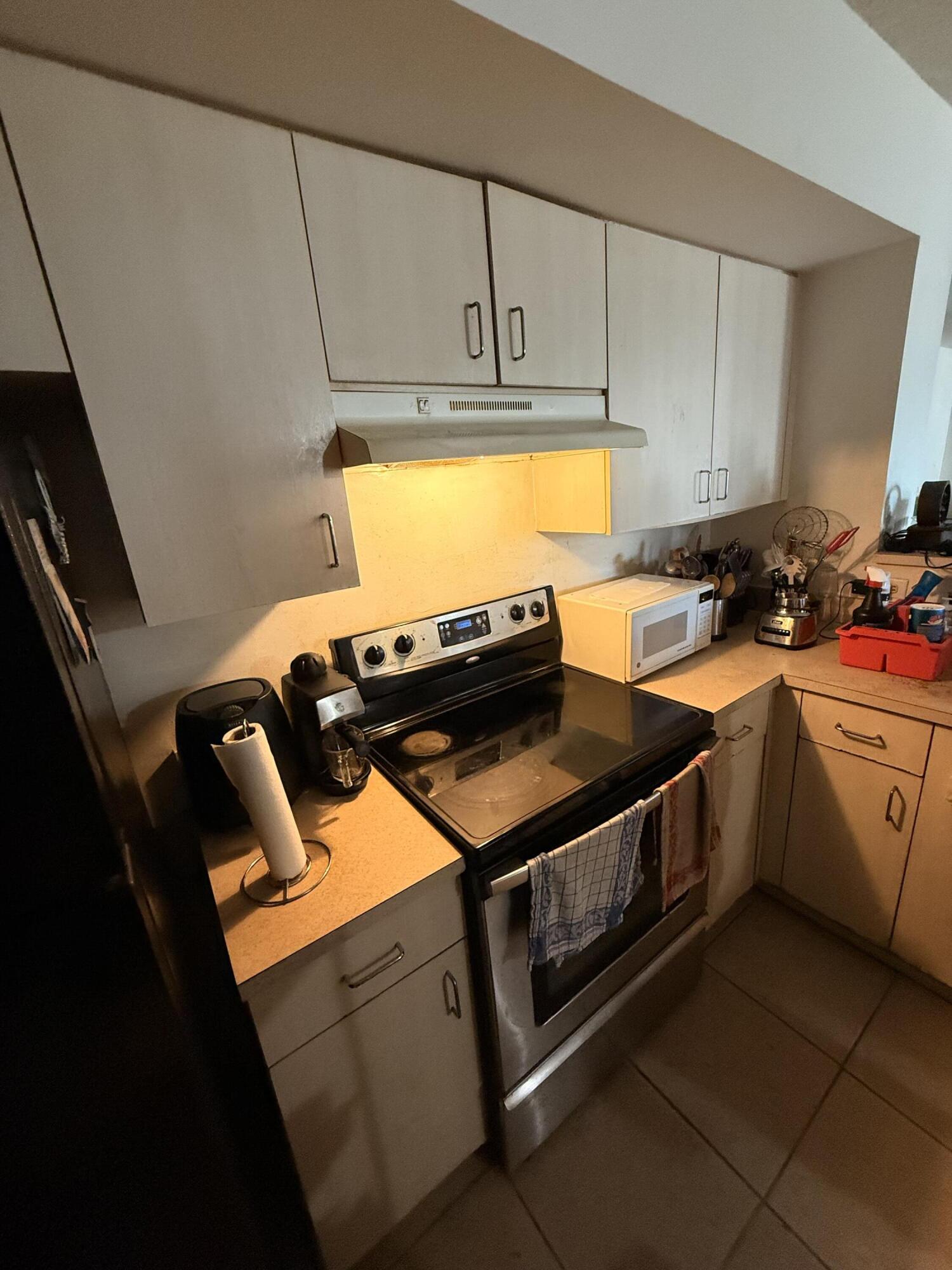 520 Southwest 111th Avenue, Unit 202 Pembroke Pines, FL 33025 - Photo 7 of 20 a kitchen with stainless steel appliances granite countertop a stove a sink and a microwave