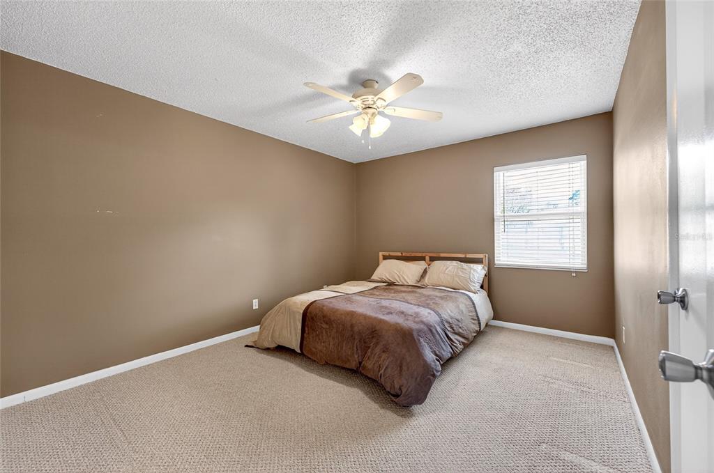 1409 Bryan Road Brandon, FL 33511 - Photo 30 of 73 a bedroom with a bed and a chandelier