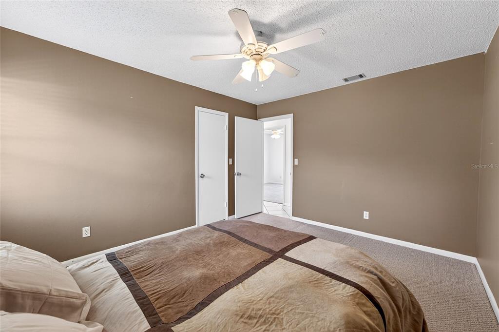 1409 Bryan Road Brandon, FL 33511 - Photo 31 of 73 a bedroom with a large bed and a ceiling fan