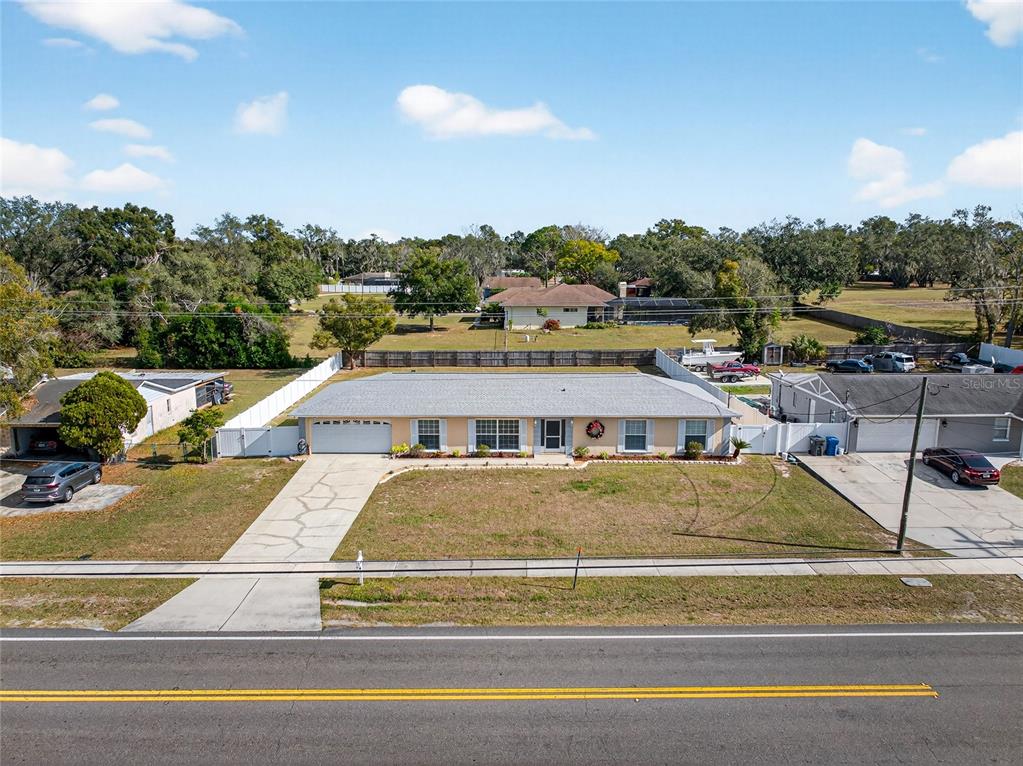 1409 Bryan Road Brandon, FL 33511 - Photo 48 of 73 a view of a white house with a swimming pool and a yard
