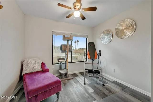 a room with gym equipment and wooden floor