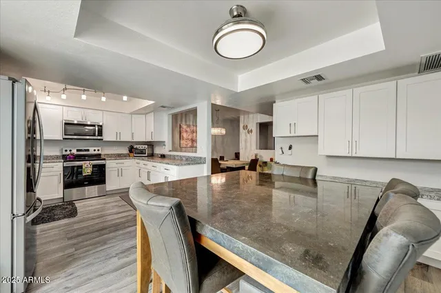 a kitchen with stainless steel appliances granite countertop a stove top oven a sink a counter space and cabinets