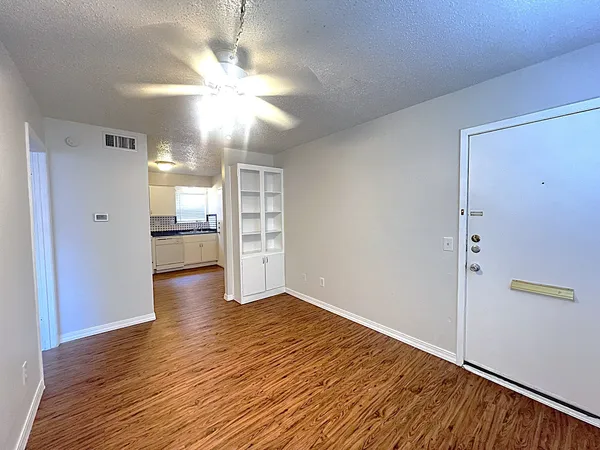 a view of a kitchen with wooden floor and a refrigerator