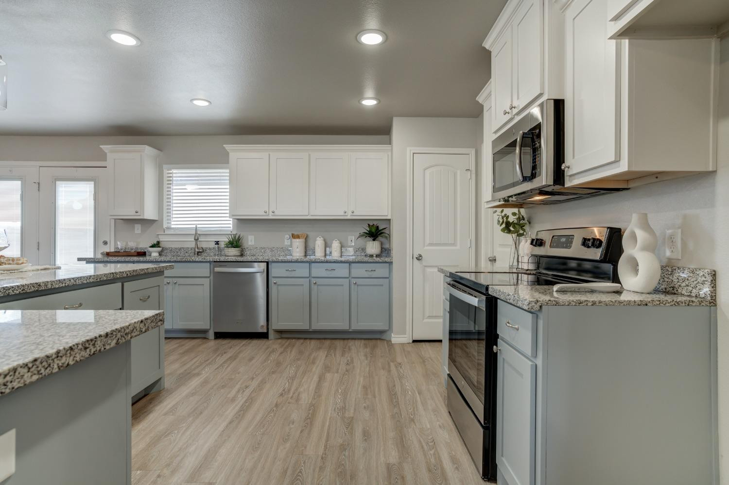 9013 County Road 6100 Shallowater, TX 79363 - Photo 21 of 49 a kitchen with granite countertop wooden floors stainless steel appliances and sink
