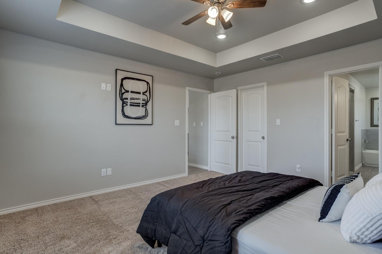 9013 County Road 6100 Shallowater, TX 79363 - Photo 31 of 49 a bedroom with a large bed and a chandelier