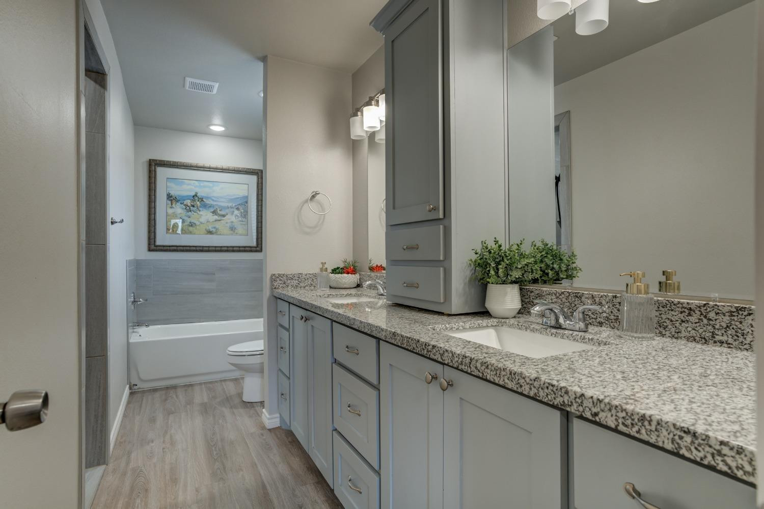 9013 County Road 6100 Shallowater, TX 79363 - Photo 34 of 49 a bathroom with a granite countertop sink a toilet and bathtub