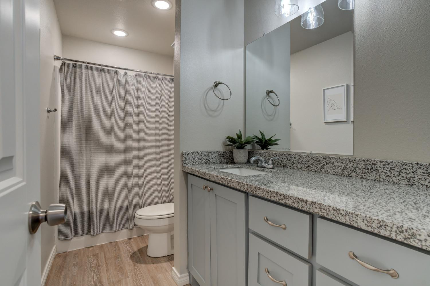 9013 County Road 6100 Shallowater, TX 79363 - Photo 42 of 49 a bathroom with a granite countertop sink a toilet and shower