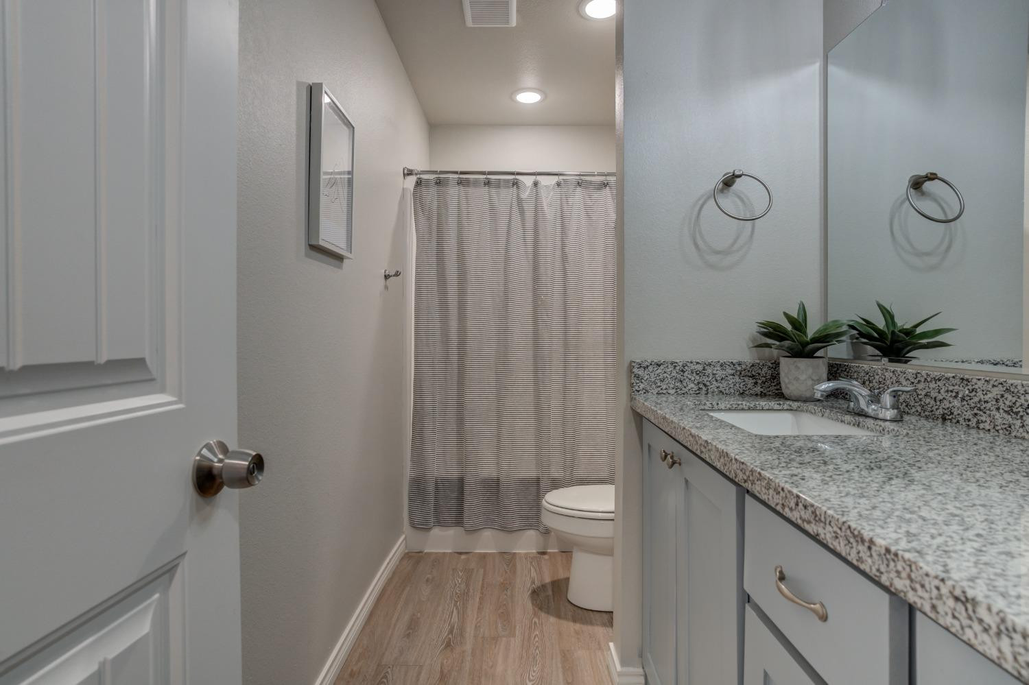 9013 County Road 6100 Shallowater, TX 79363 - Photo 43 of 49 a bathroom with a granite countertop sink a toilet and shower