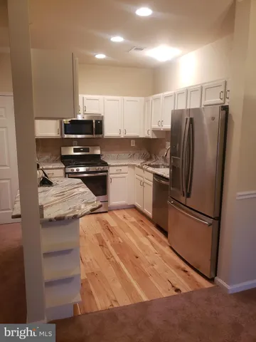 a kitchen with stainless steel appliances granite countertop a refrigerator and a stove