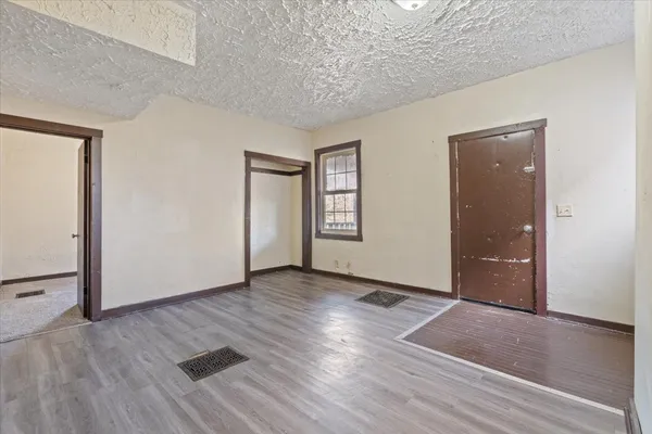 an empty room with wooden floor and windows
