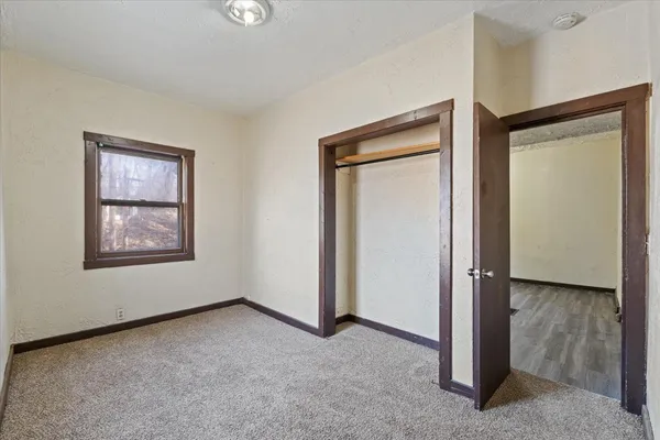 an empty room with windows and closet