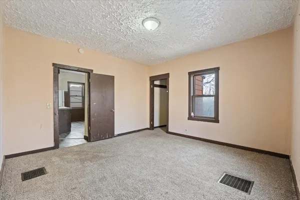 an empty room with windows and closet