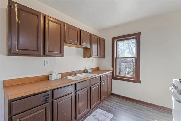 a kitchen with a sink cabinets and wooden floor