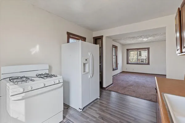 a kitchen with a stove a refrigerator and a wooden floors