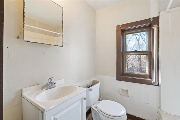 a bathroom with a toilet sink and mirror
