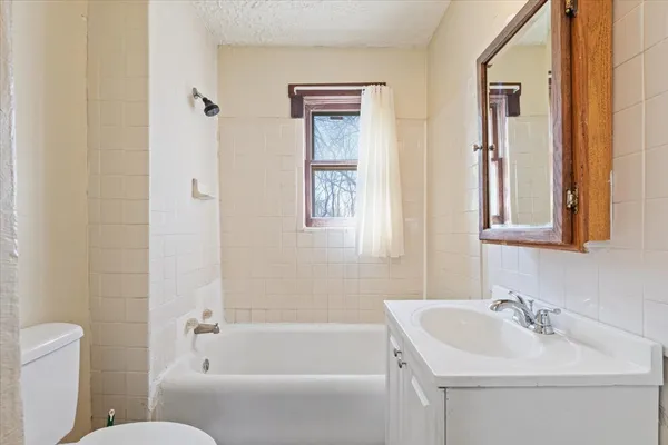 a bathroom with a tub a sink and mirror