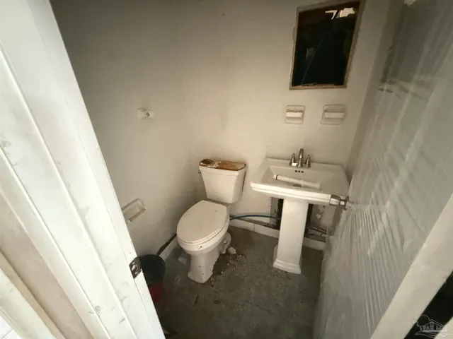 a white toilet sitting next to a sink and vanity