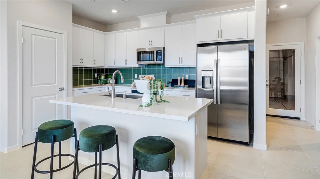 2571 Cloudview Privado Ontario, CA 91761 - Photo 2 of 19 a kitchen with stainless steel appliances a refrigerator a stove a sink and white cabinets