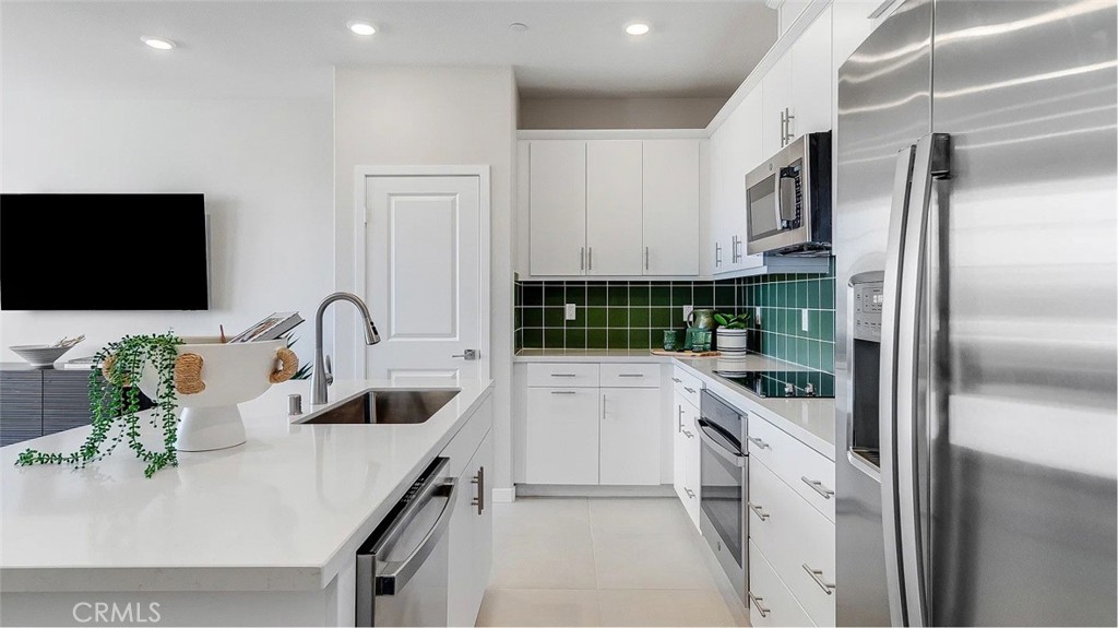 2571 Cloudview Privado Ontario, CA 91761 - Photo 3 of 19 a kitchen with white cabinets and stainless steel appliances