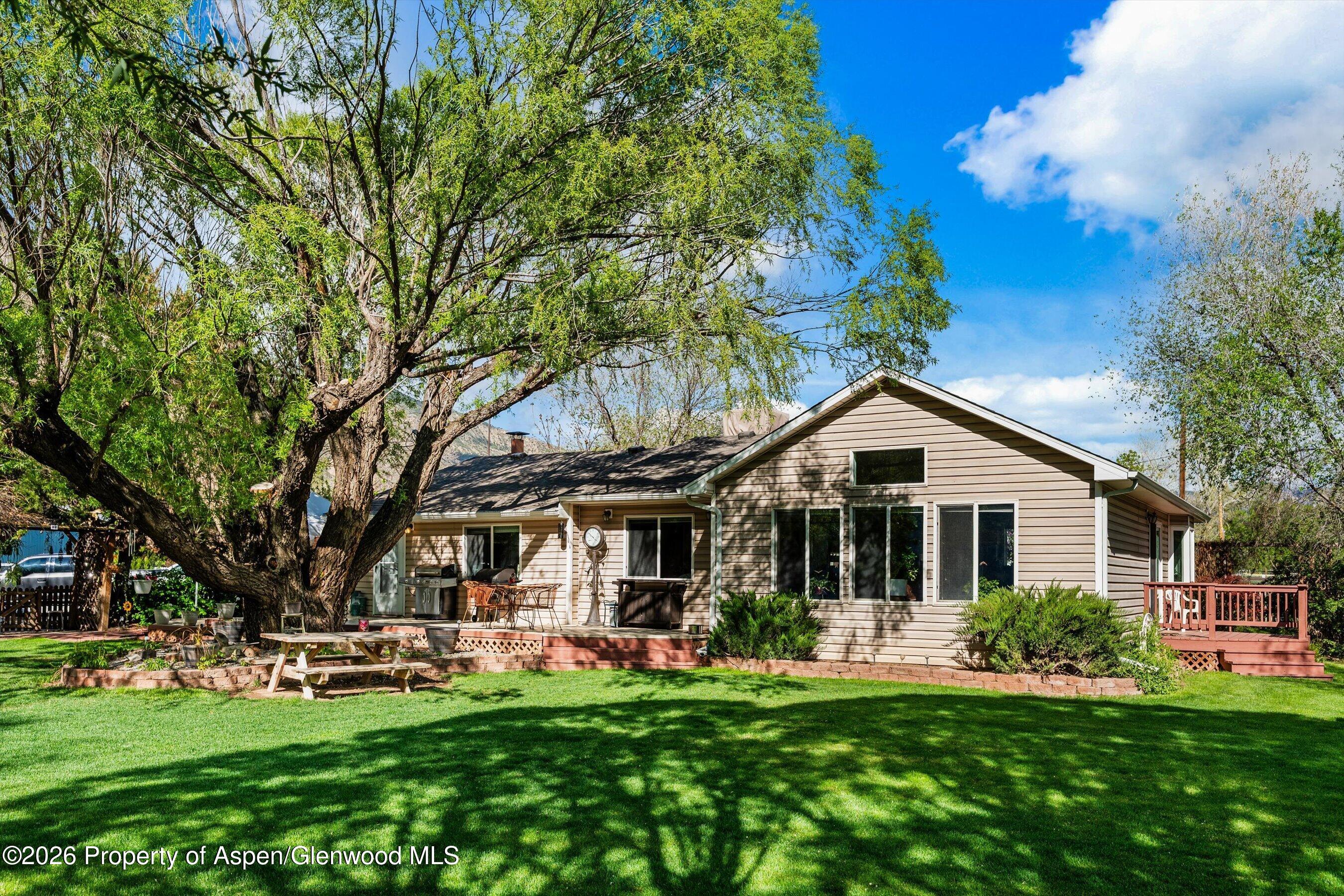 a front view of a house with a garden and trees