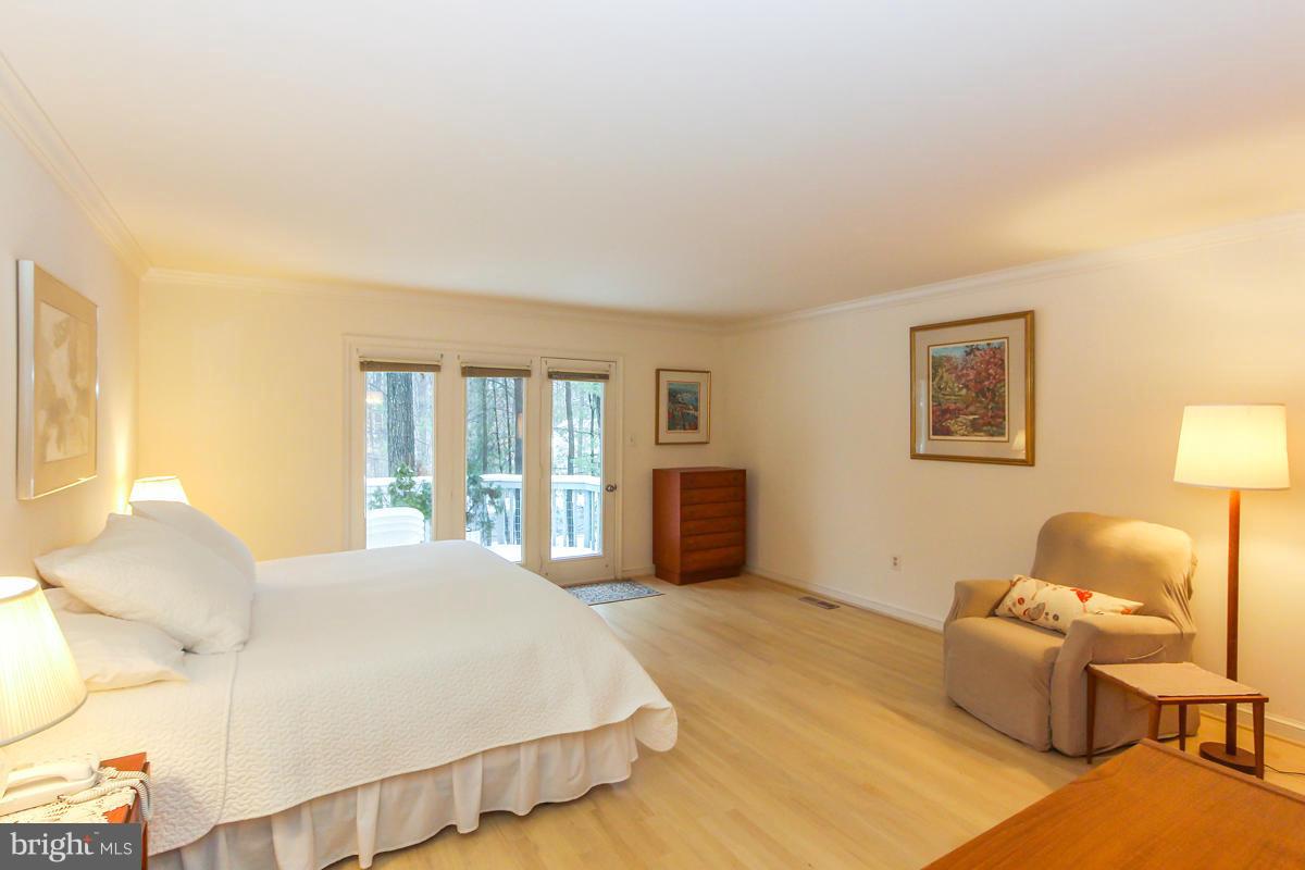 1587 Regatta Lane Reston, VA 20194 - Photo 11 of 30 a spacious bedroom with a bed and lamp