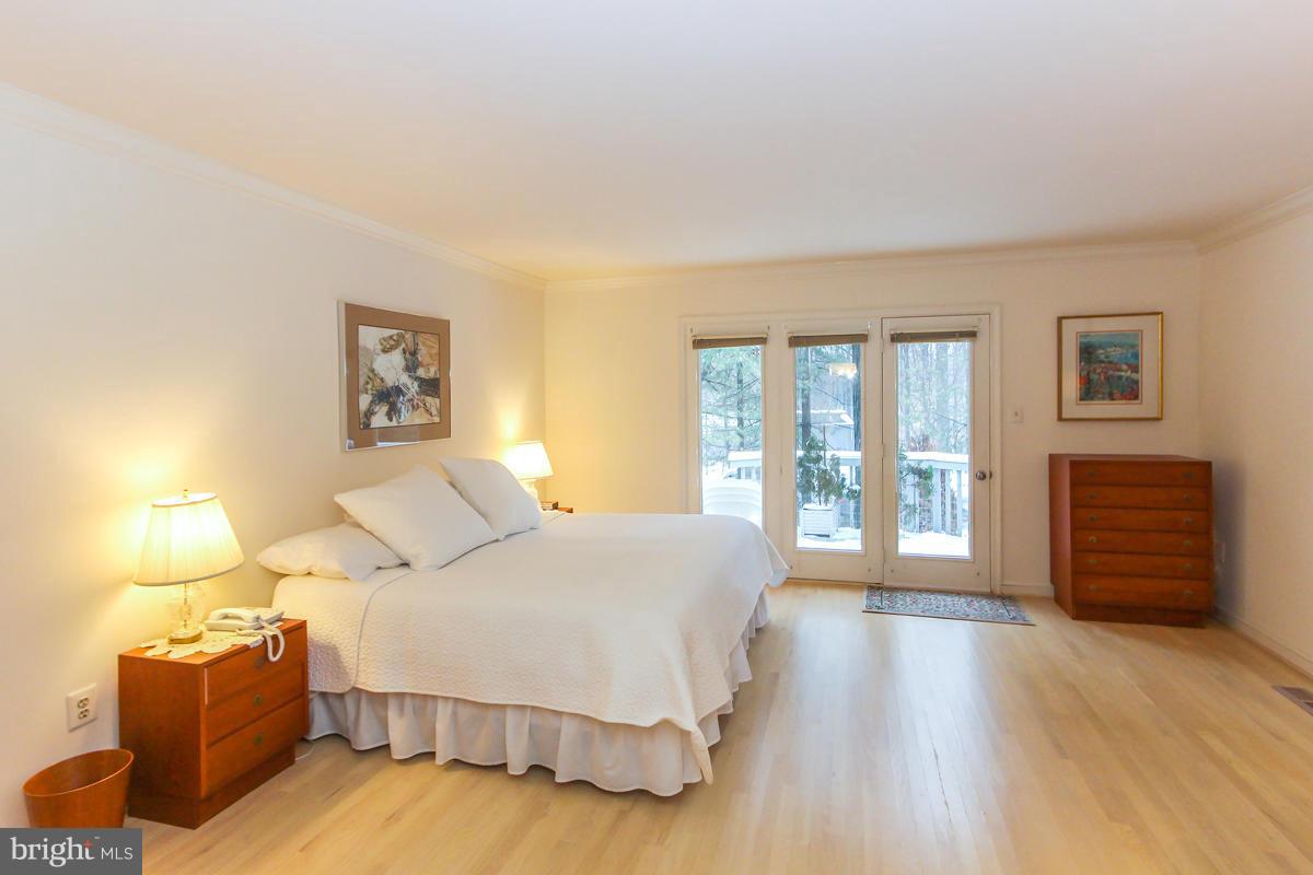 1587 Regatta Lane Reston, VA 20194 - Photo 12 of 30 a spacious bedroom with a bed and wooden floor