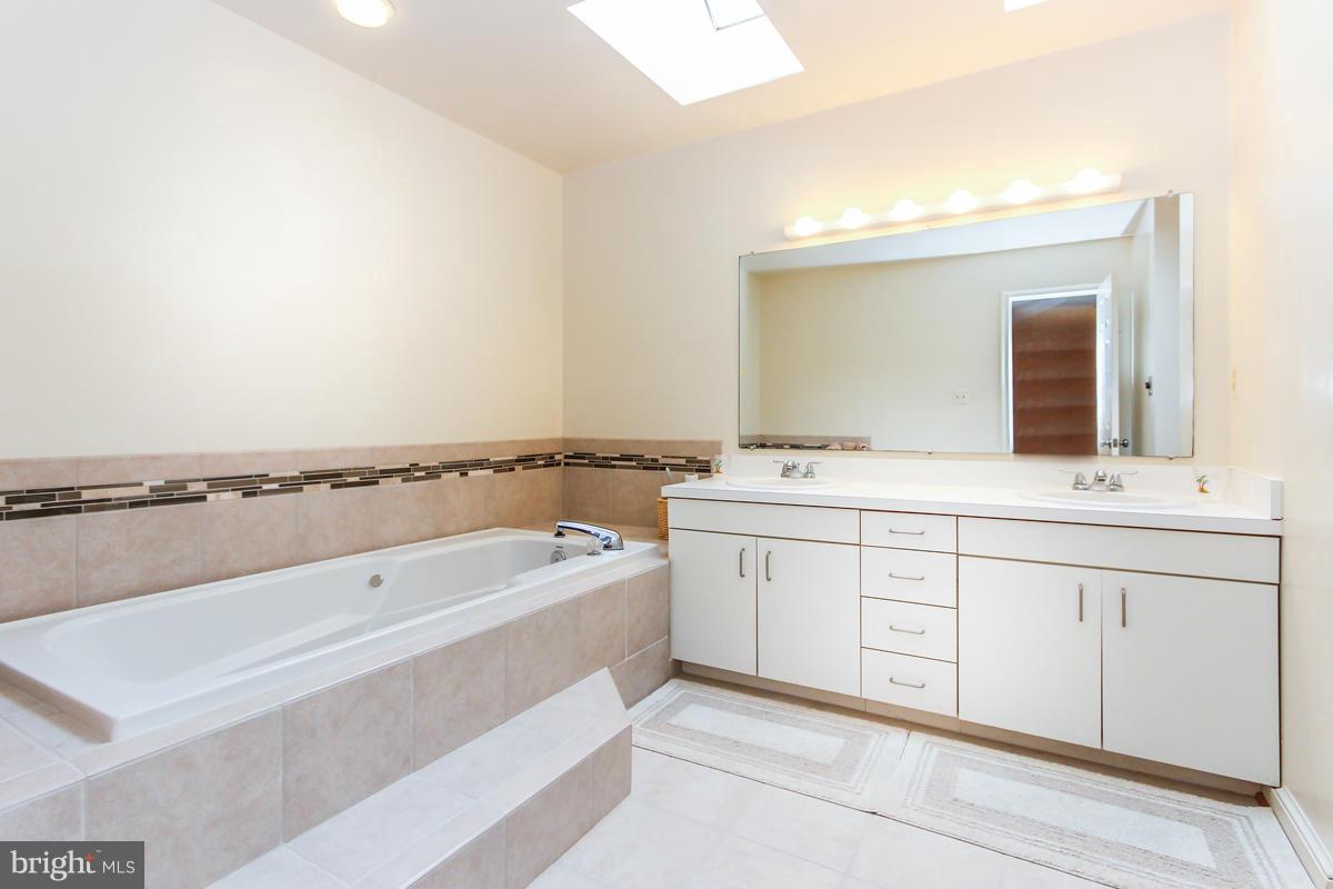 1587 Regatta Lane Reston, VA 20194 - Photo 14 of 30 a spacious bathroom with a tub sink and mirror