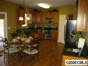 1178 Spicewood Pines Road Fort Mill, SC 29708 - Photo 2 of 8 a kitchen with stainless steel appliances kitchen island granite countertop a refrigerator a stove a microwave oven a sink with island and chairs