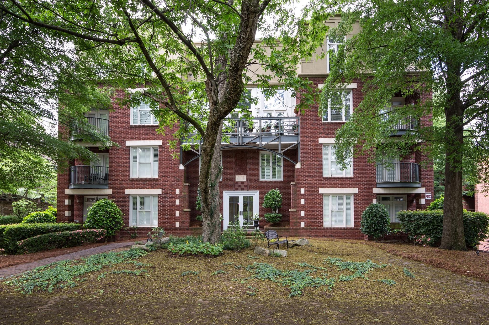 a view of a brick house with a large windows and a large tree
