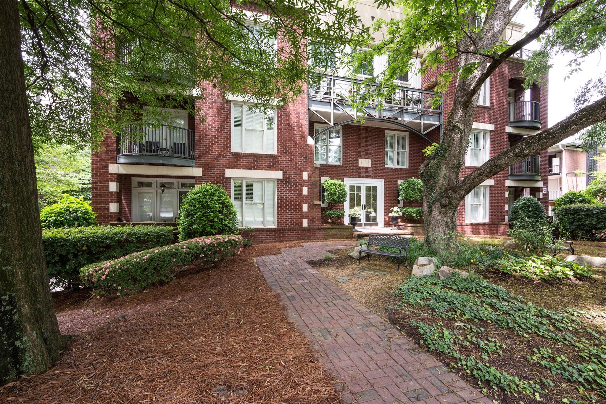 416 Queens Road, Unit 6 Charlotte, NC 28207 - Photo 3 of 37 a view of a brick building next to a yard