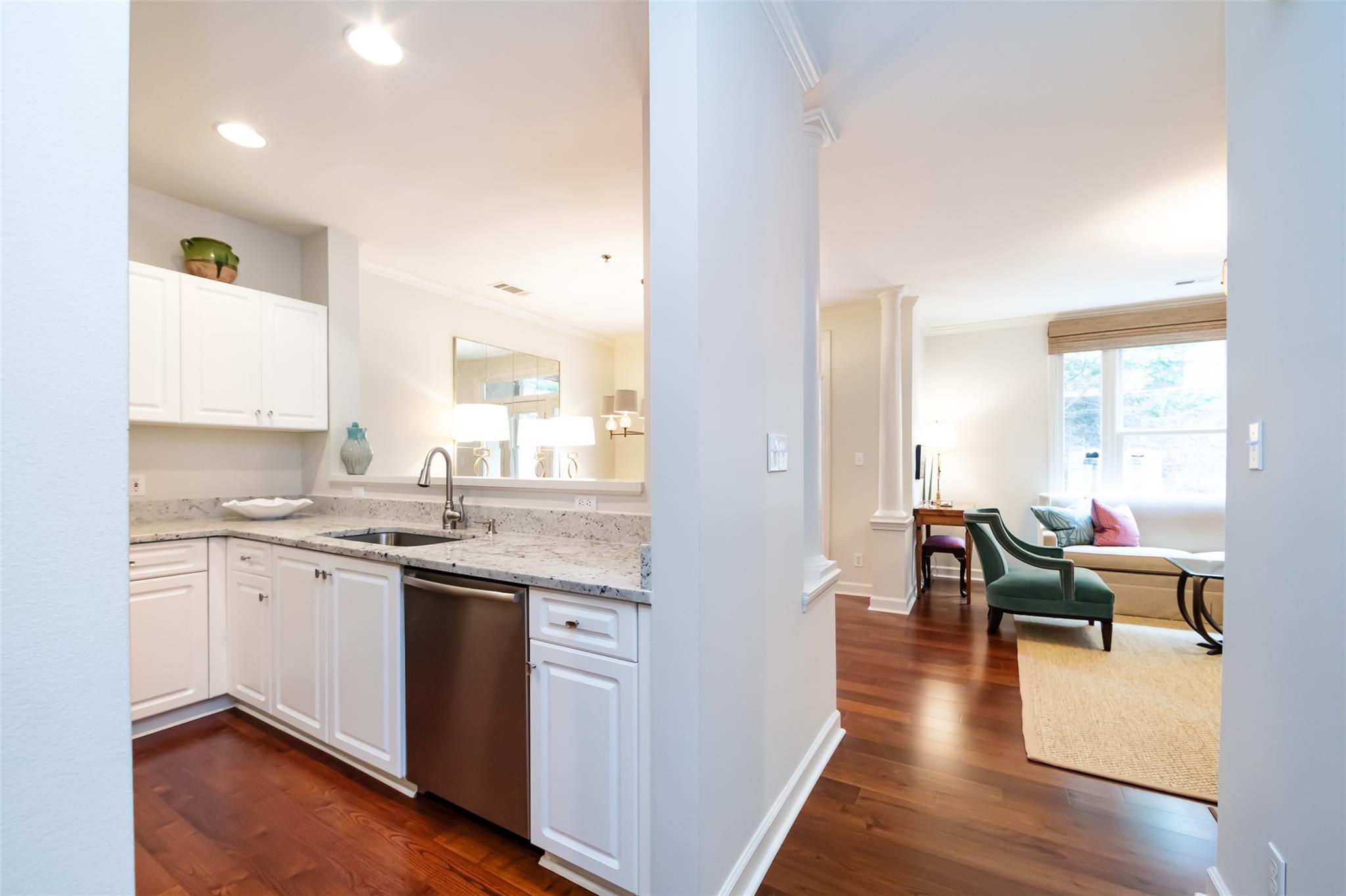 416 Queens Road, Unit 6 Charlotte, NC 28207 - Photo 8 of 37 a open kitchen with granite countertop a stove top oven a sink dishwasher and white cabinets with wooden floor