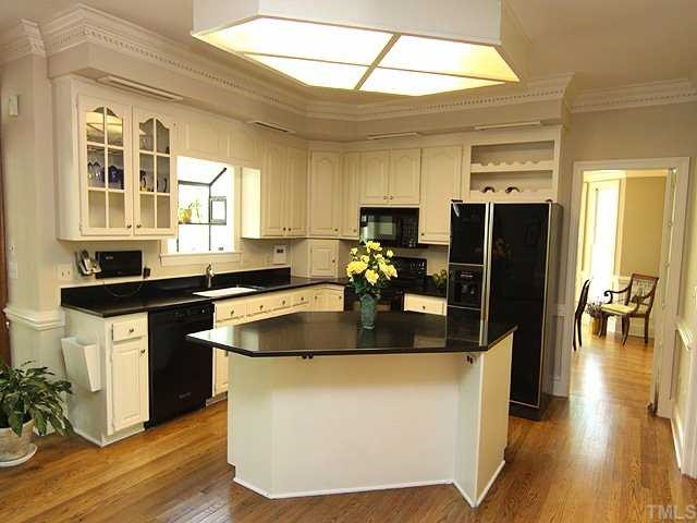 12209 Glenlivet Way Raleigh, NC 27613 - Photo 5 of 17 a kitchen with stainless steel appliances granite countertop a sink a stove and a refrigerator