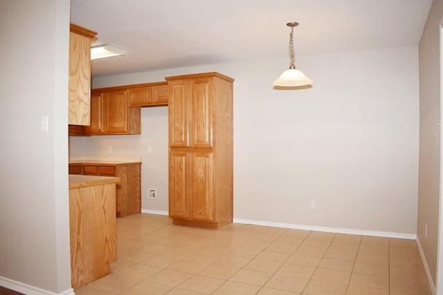 760-764 Stribling Circle Azle, TX 76020 - Photo 11 of 18 Kitchen with light countertops, decorative light fixtures, and light tile patterned floors