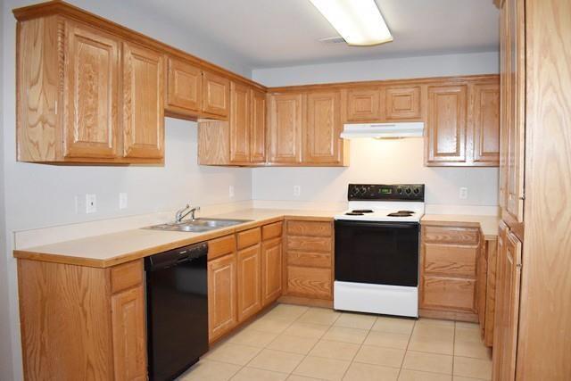 760-764 Stribling Circle Azle, TX 76020 - Photo 13 of 18 Kitchen with white electric stove, light countertops, black dishwasher, and light tile patterned floors