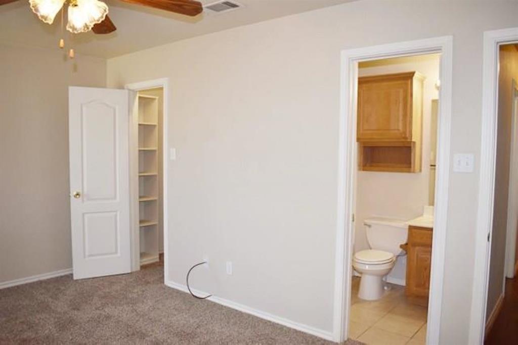 760-764 Stribling Circle Azle, TX 76020 - Photo 7 of 18 Unfurnished bedroom featuring a walk in closet, ceiling fan, light colored carpet, and ensuite bathroom