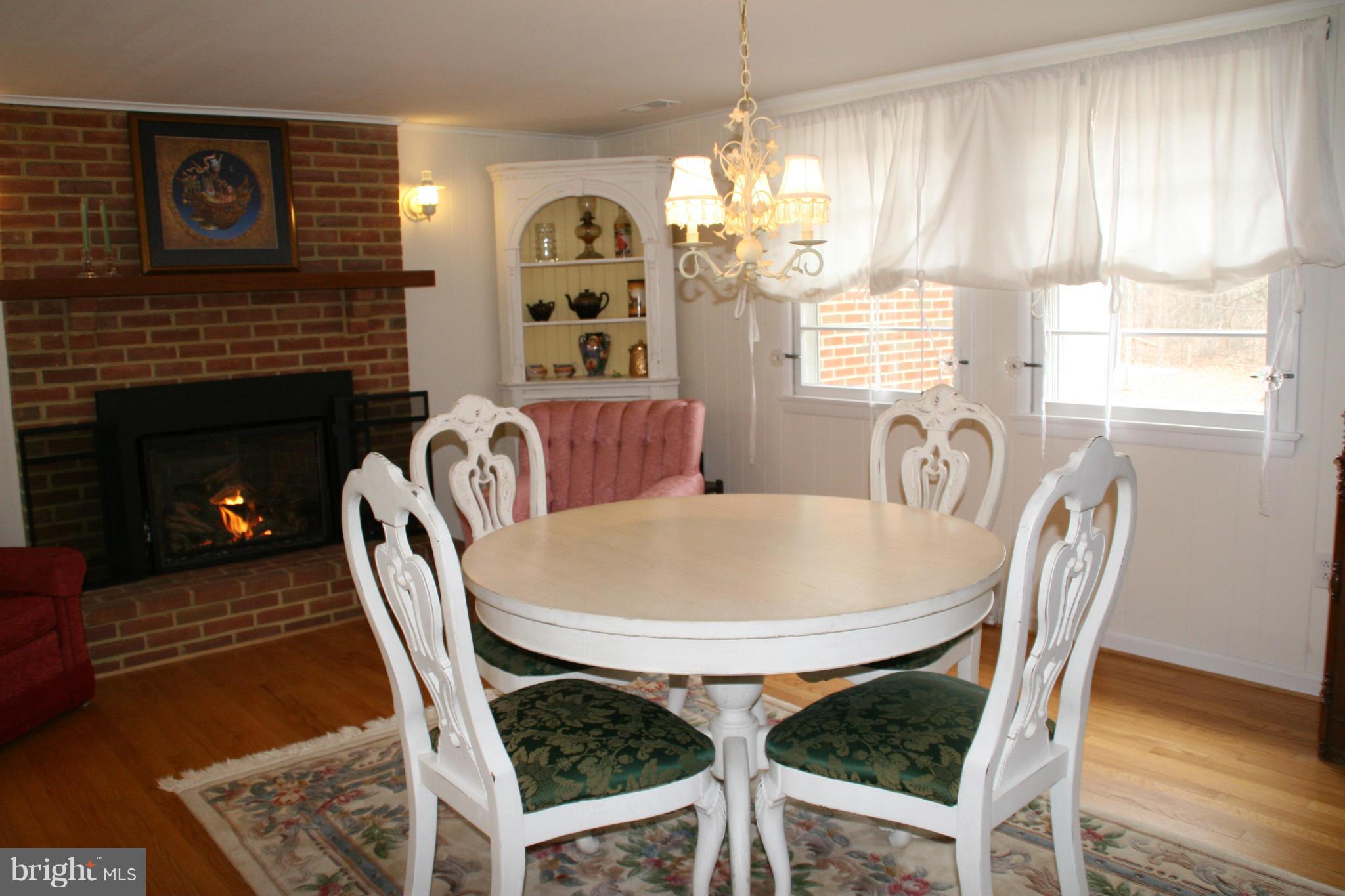 6606 Howellsville Road Front Royal, VA 22630 - Photo 4 of 30 a dining room with furniture a fireplace and wooden floor