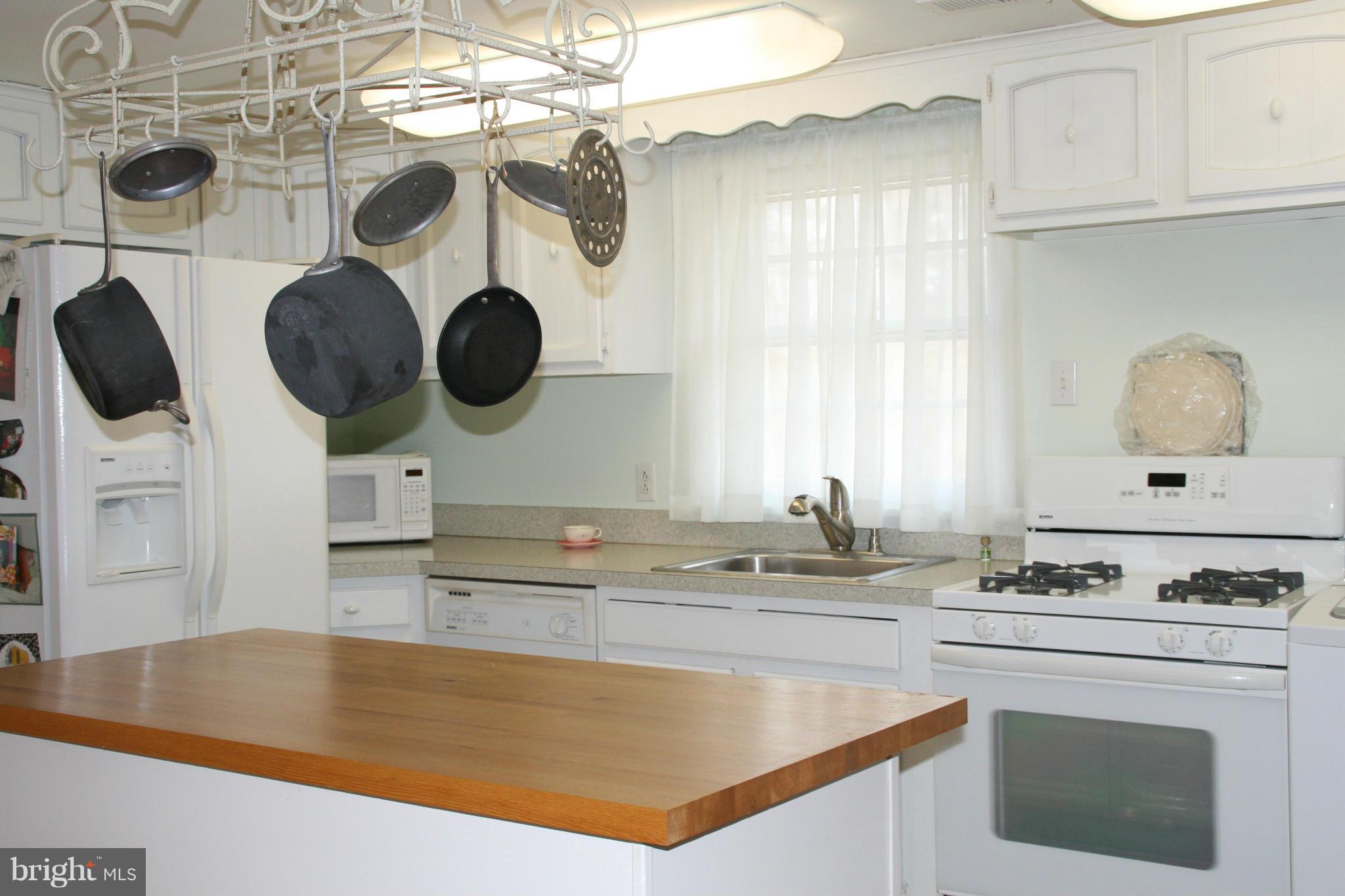 6606 Howellsville Road Front Royal, VA 22630 - Photo 8 of 30 a kitchen with a sink a stove and a clock on the wall