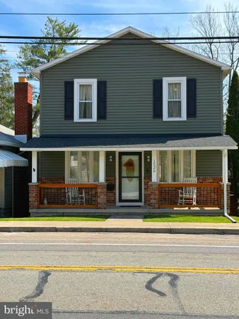 a view of a house with a yard and sitting area