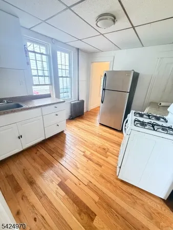 a kitchen with granite countertop a stove a sink dishwasher and a refrigerator